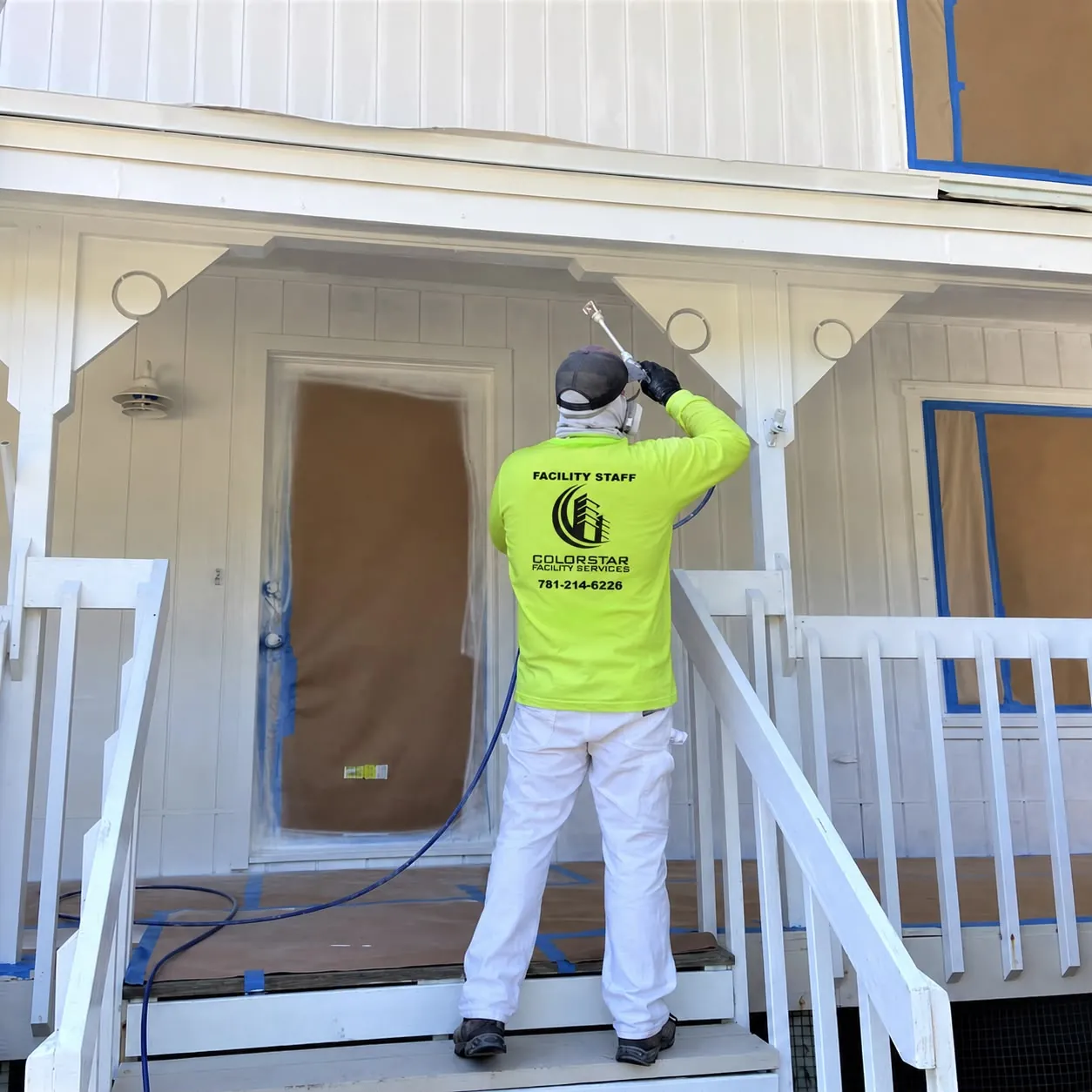A Colorstar painter spray-painting a Massachusetts home exterior
